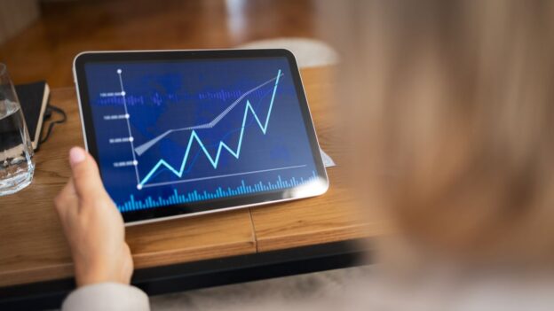 Person looking at metrics on a tablet that is increasing
