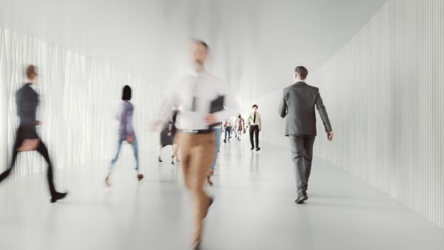 Blurry people in an office walking fast