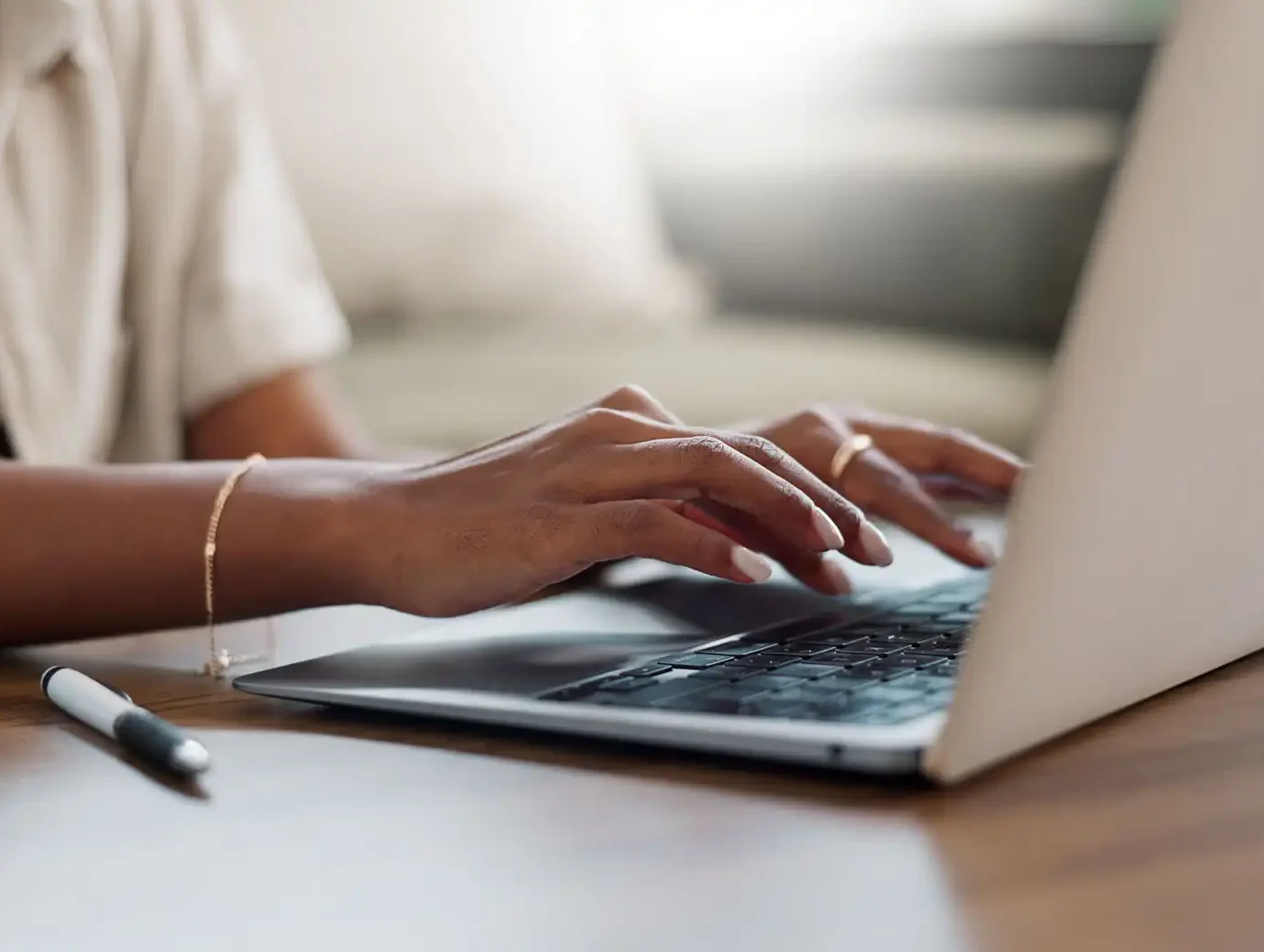 A woman types on a keyboard in an office setting.