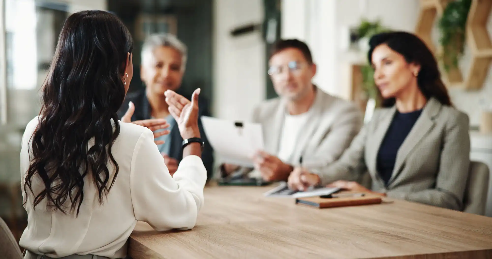 Four business professionals in a meeting at a conference table.