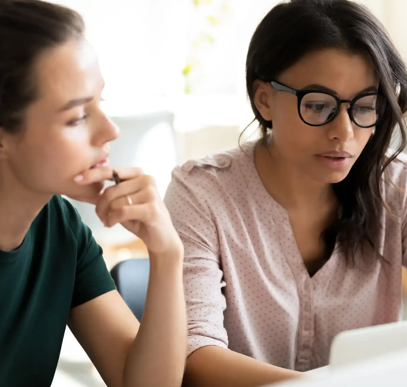 Two business professionals look at a laptop computer together.