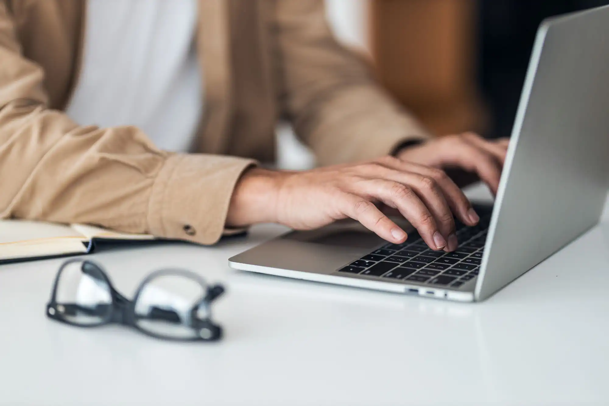 An office worker sits at a desk typing on a keyboard.